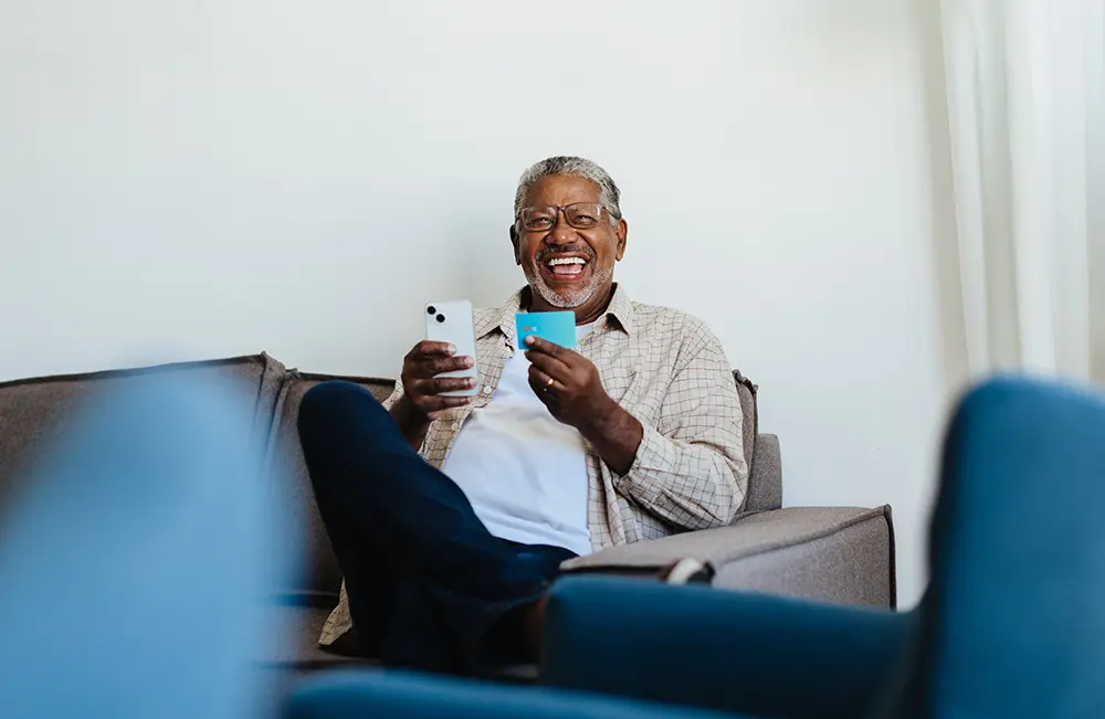 hombre feliz con su tarjeta de crédito